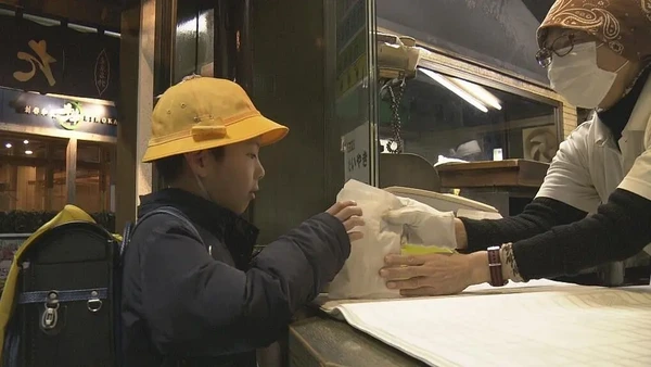 A boy receiving a packet from a staff in Documentary 72 Hours.