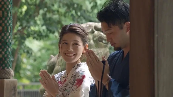 Future Diary (2021) - A praying couple smiling with hands clasped in a temple